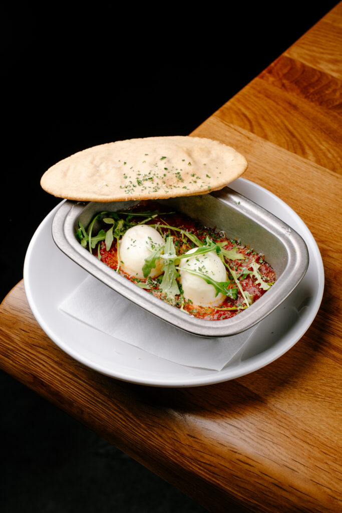 Chorizo baked eggs with tomato sauce and pita bread at Nesso Leeds brunch